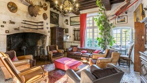 Une pièce rustique, avec des meubles en cuir, une cheminée et des trophées de chasse accrochés au mur.