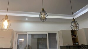 A modern kitchen with pendant lights, a sliding glass door, and built-in cabinets. - À 5 min du Parc Carthage Land! Magnifique Villa Avec Piscine Creusée à Louer (Hammamet)