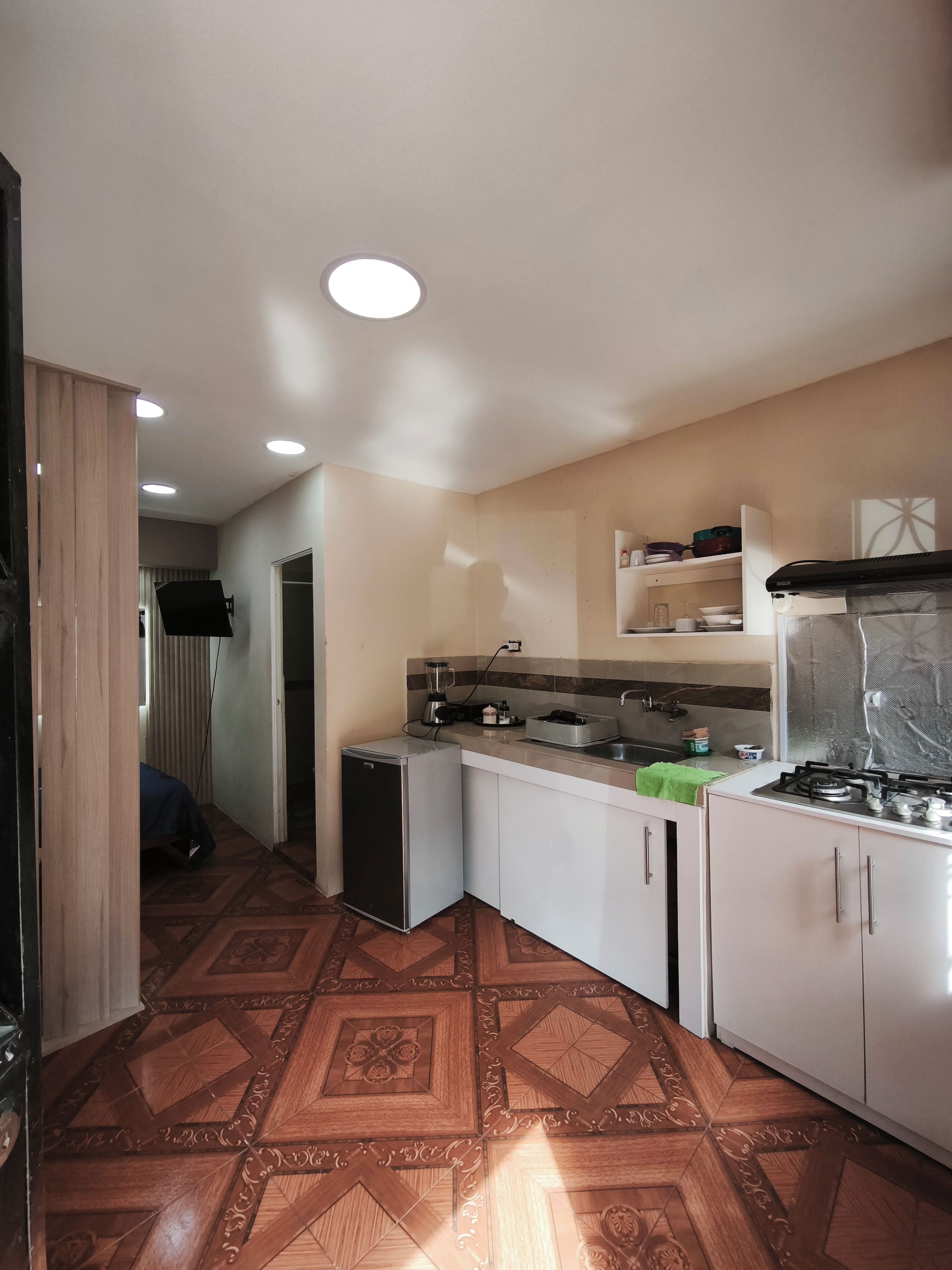 A compact kitchen with a refrigerator, stove, and countertop appliances.