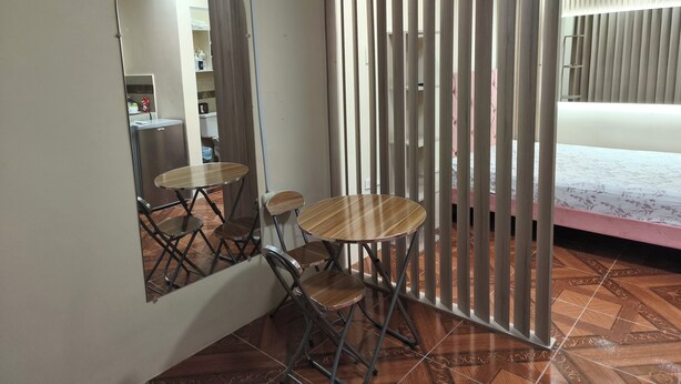 Ein Zimmer mit Bett, Spiegel, Tisch und Stühlen.