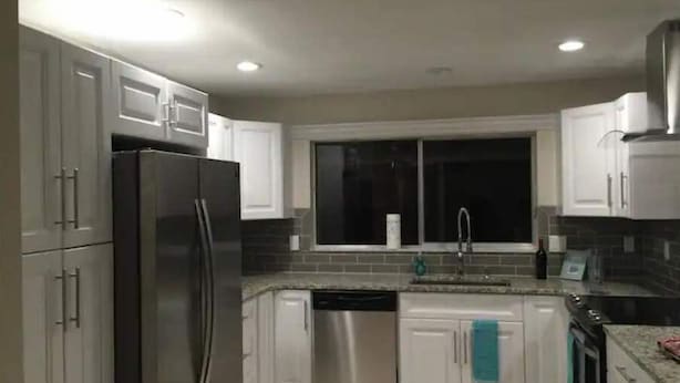 A modern kitchen with white cabinets, stainless steel appliances, and a window above the sink. - Waterfront Getaway in Charming Beach Town! (Port Charlotte)