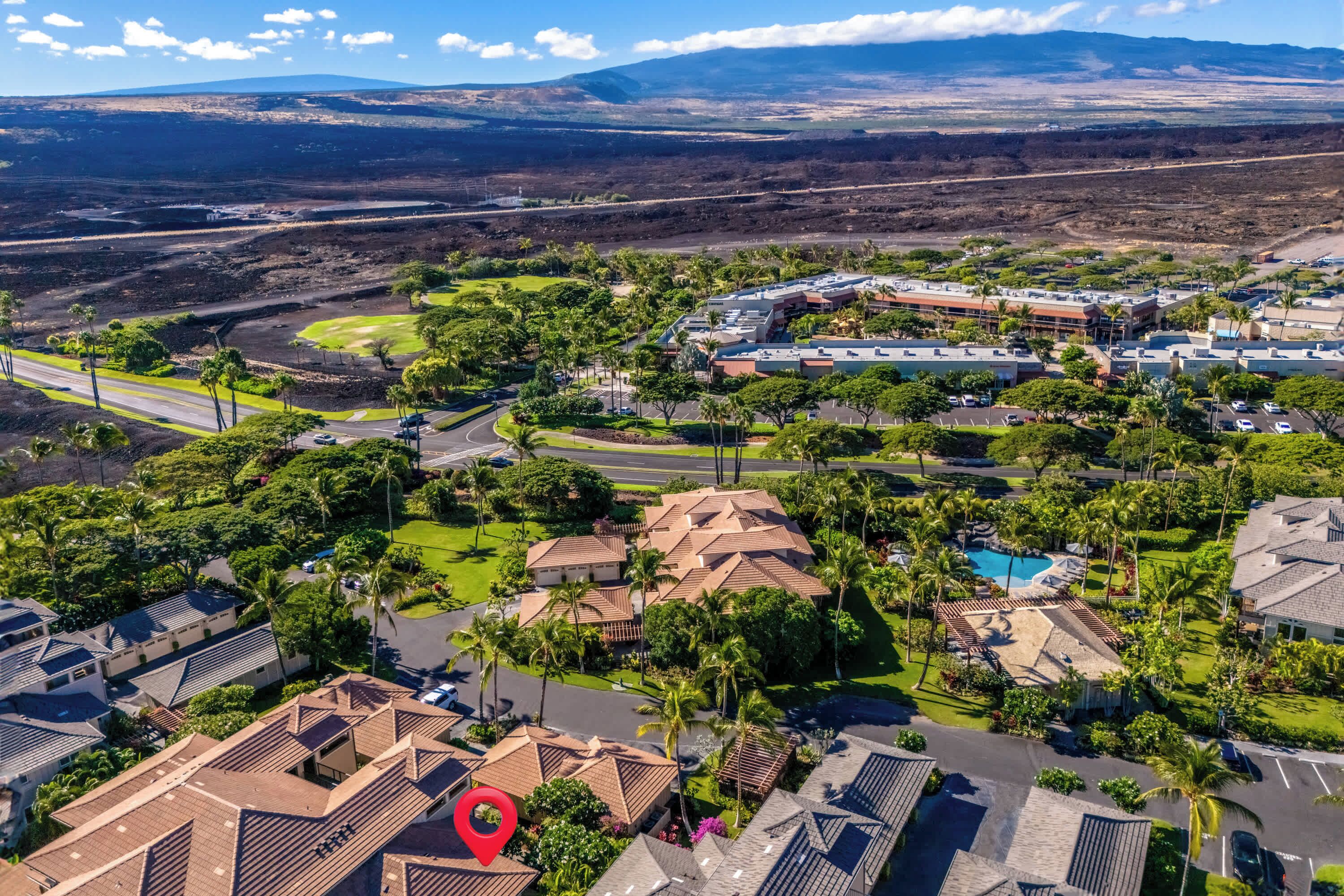 A residential area with houses, a swimming pool, and a large building complex.