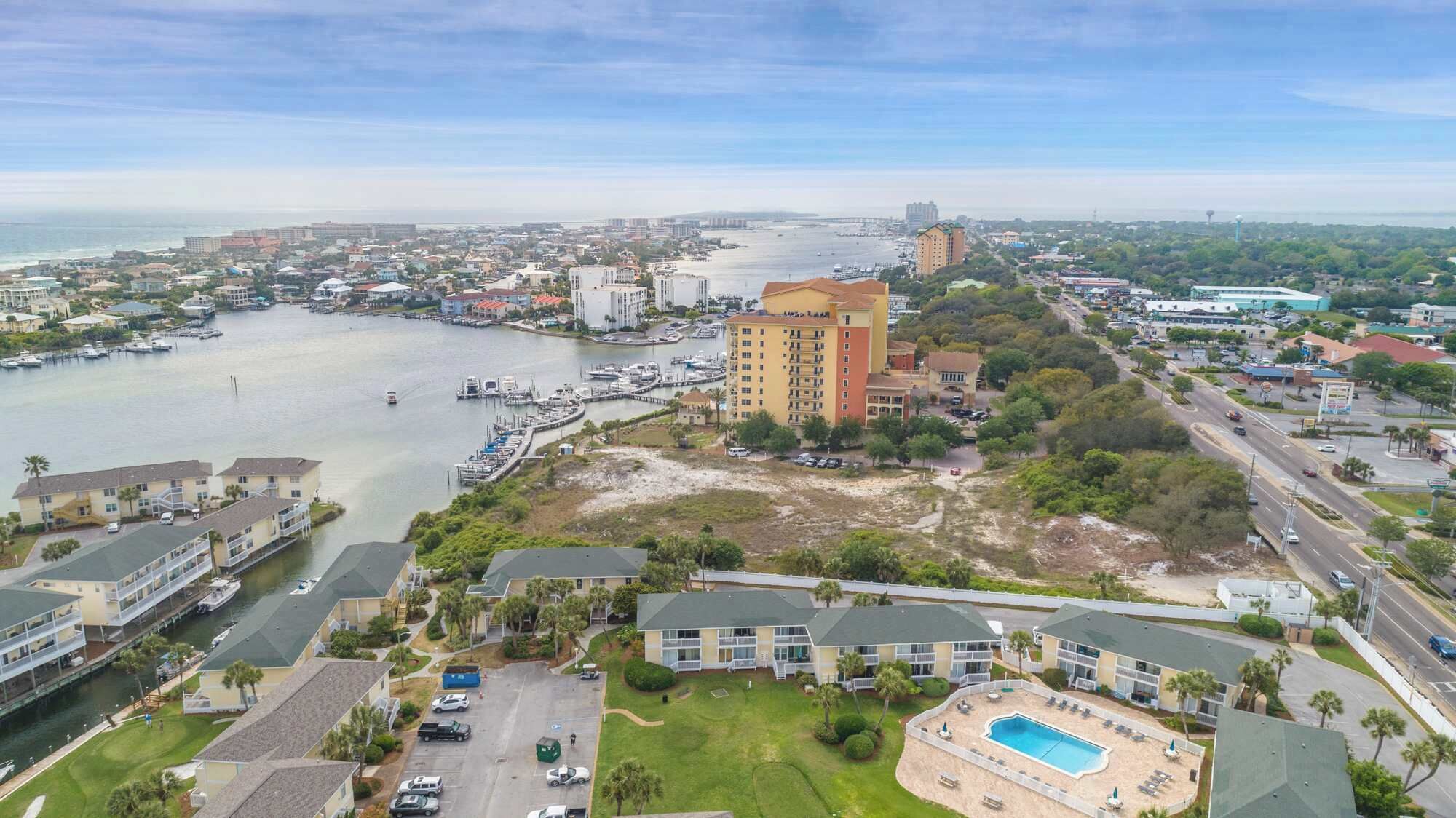 A coastal hotel with multiple buildings, a marina, and a large pool area.