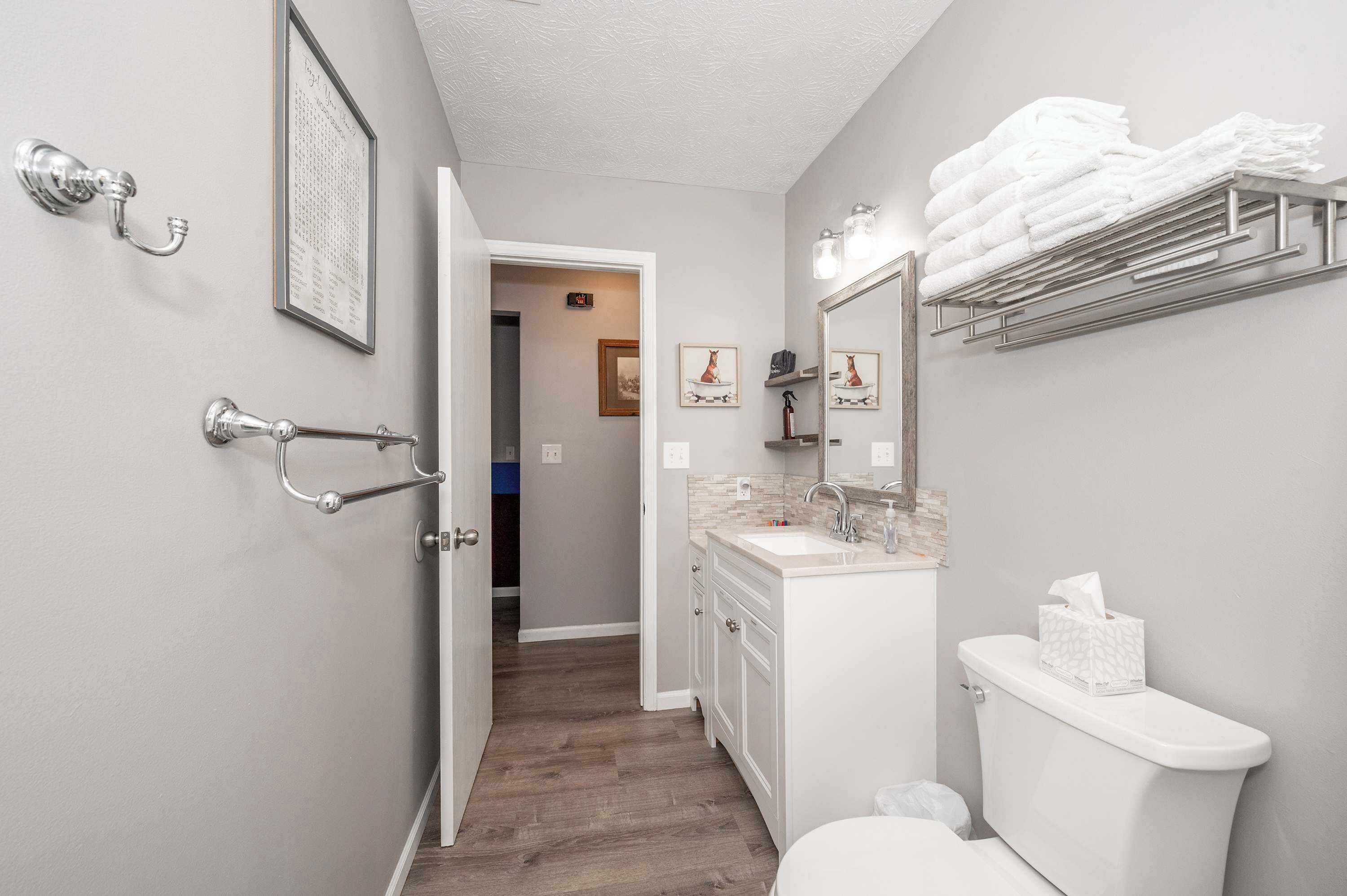 Une salle de bain équipée de toilettes, d’un lavabo et d’un porte-serviettes.