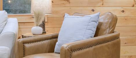 A cozy room with a leather sofa, a lamp, and a decorative wall.