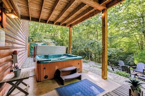 A hot tub in a covered outdoor area with steps leading up to it, surrounded by greenery. - Misty Creek Cabin Private 3 BDR w/ Game Room! (Blue Ridge)
