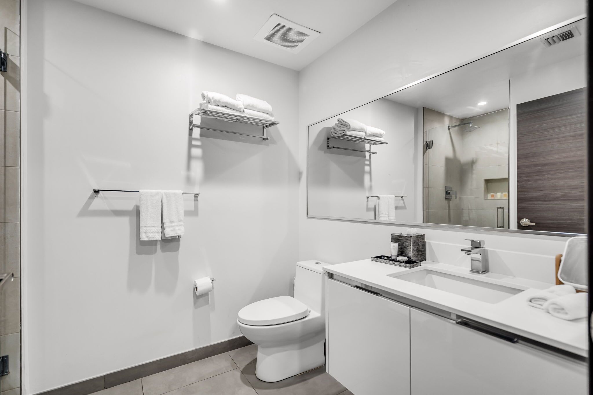 Un baño moderno con inodoro, lavamanos y toalleros.