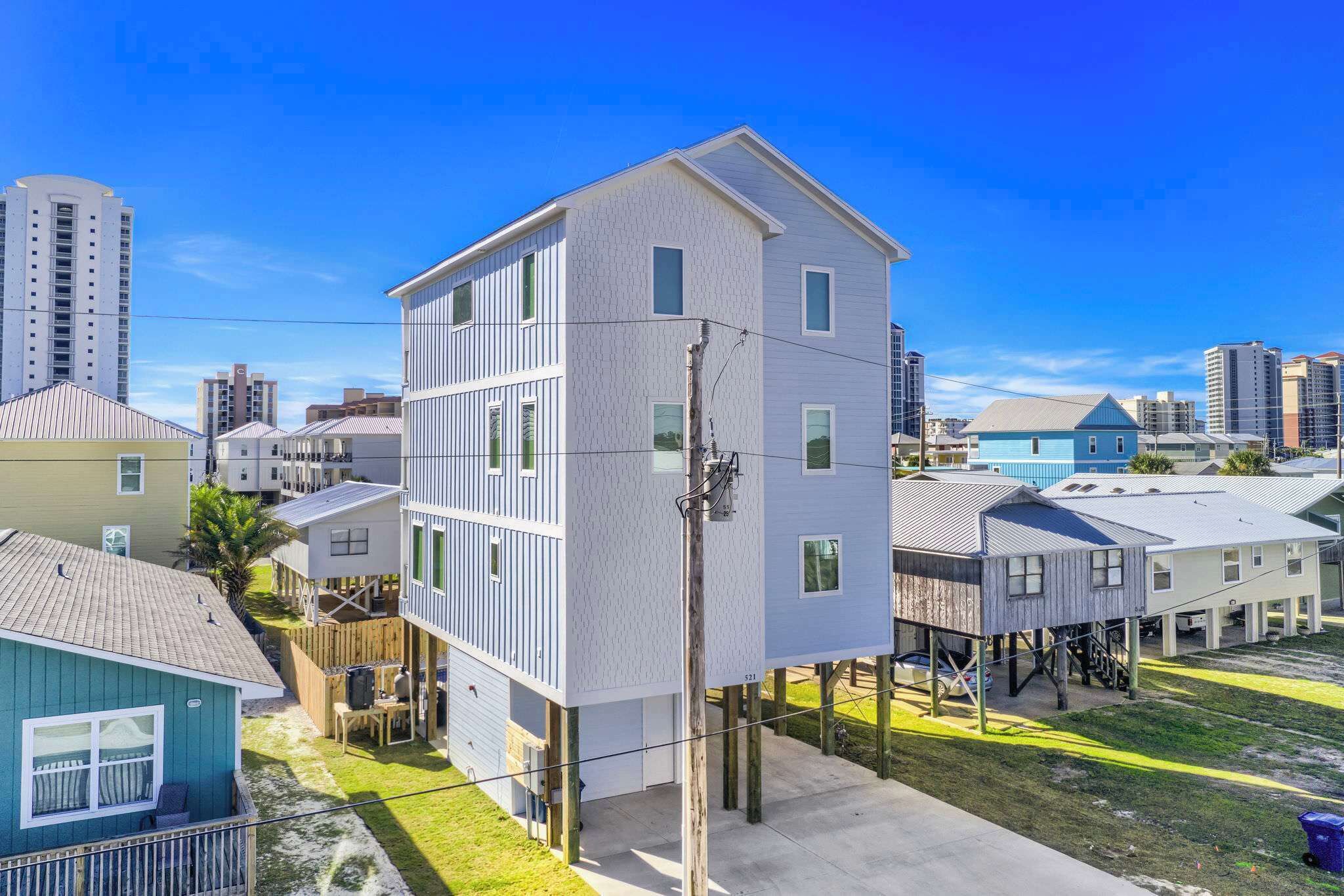 A multi-story residential building with a white exterior, a balcony, and a garage.