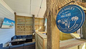 A tiki bar with a wooden interior, a sign reading "Beach Haven's Tiki Bar," and a view of the beach through a window. - 8 Bed 9 Bath Private Pool Grill Walk to Beach (Gulf Shores)