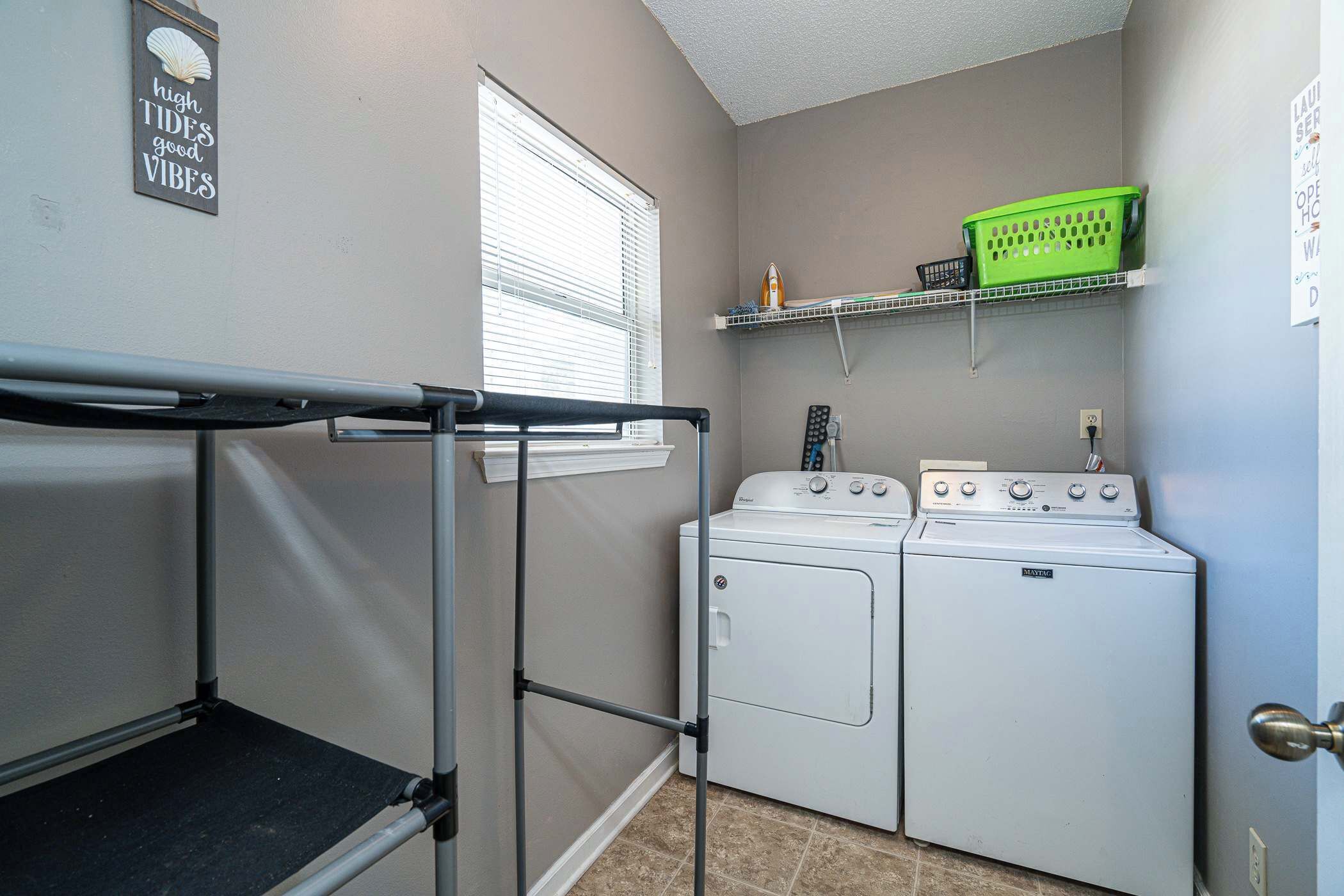 A laundry area with a washing machine, dryer, and a drying rack.