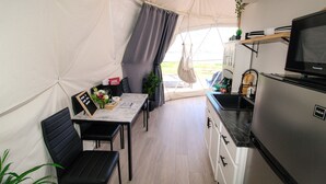 Cocina compacta con refrigerador, microondas y una planta colgante.