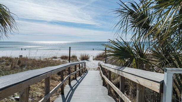 A wooden boardwalk leading to a beach with clear skies and calm waters. - The Turtle Nest Resort Condo w/ Pool! (Panama City Beach)