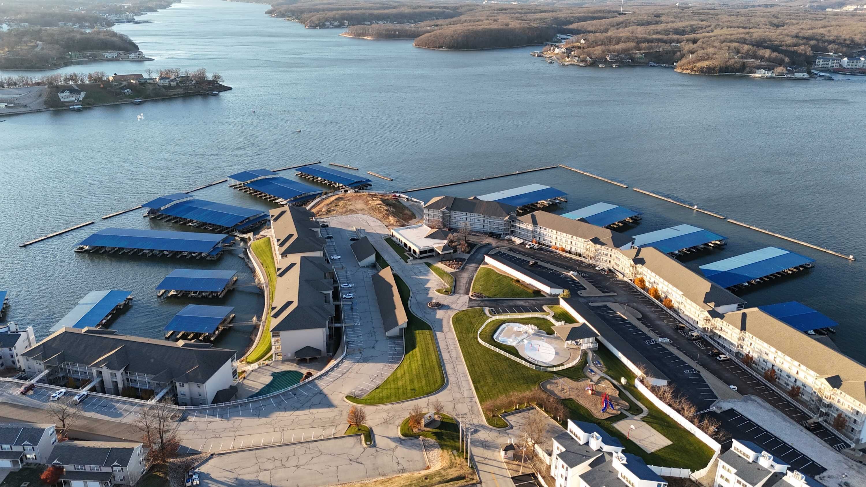 Oversigtsbillede af et hotel ved vandet med flere bygninger, en lysthavn og en parkeringsplads.