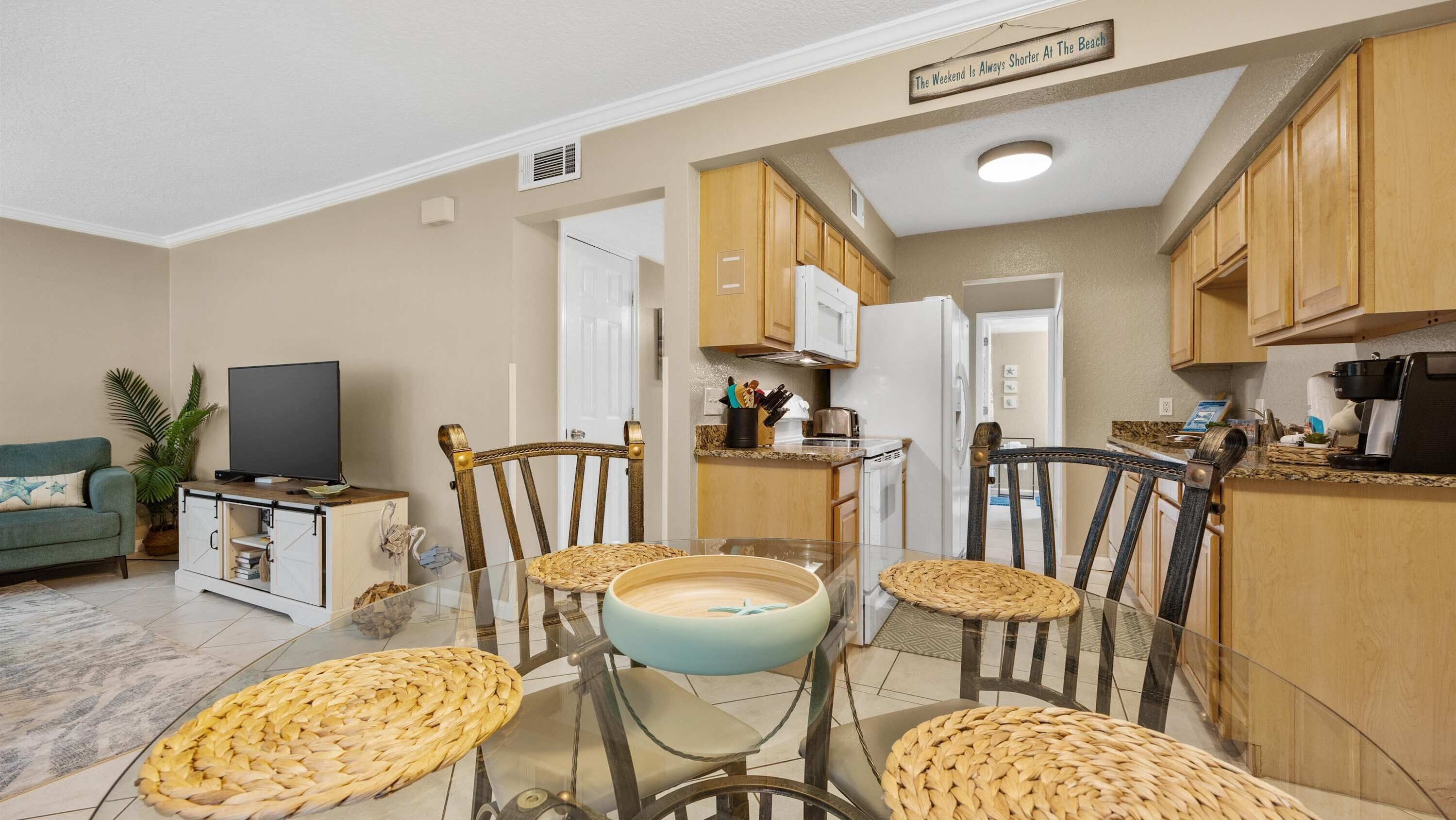 Un espacio habitable compacto con zona de comedor, kitchenette y televisor.