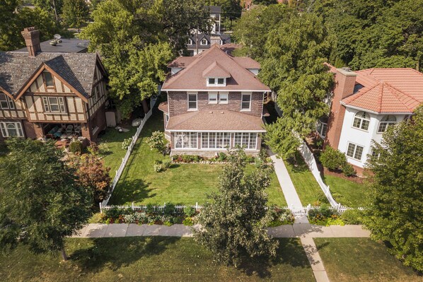 A large house with a prominent front porch, a garage, and a well-maintained lawn.