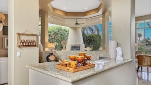 A modern kitchen with a central island, a built-in oven, and a view of the outdoors.