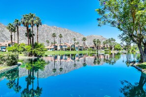 Un complexe hôtelier comprenant plusieurs villas, une piscine à l’eau cristalline et un paysage montagneux en toile de fond.