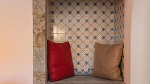 A cozy corner with a bench, two pillows, and a woven blanket. - Chalet Maria da Assunção - Studio (Cascais)