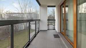 Un balcón moderno con puertas de cristal y vista a una zona residencial.