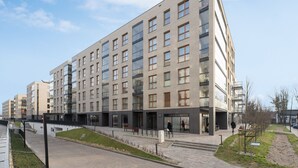 Un edificio moderno de varios pisos con fachada plana, amplios ventanales y entrada a nivel de calle.