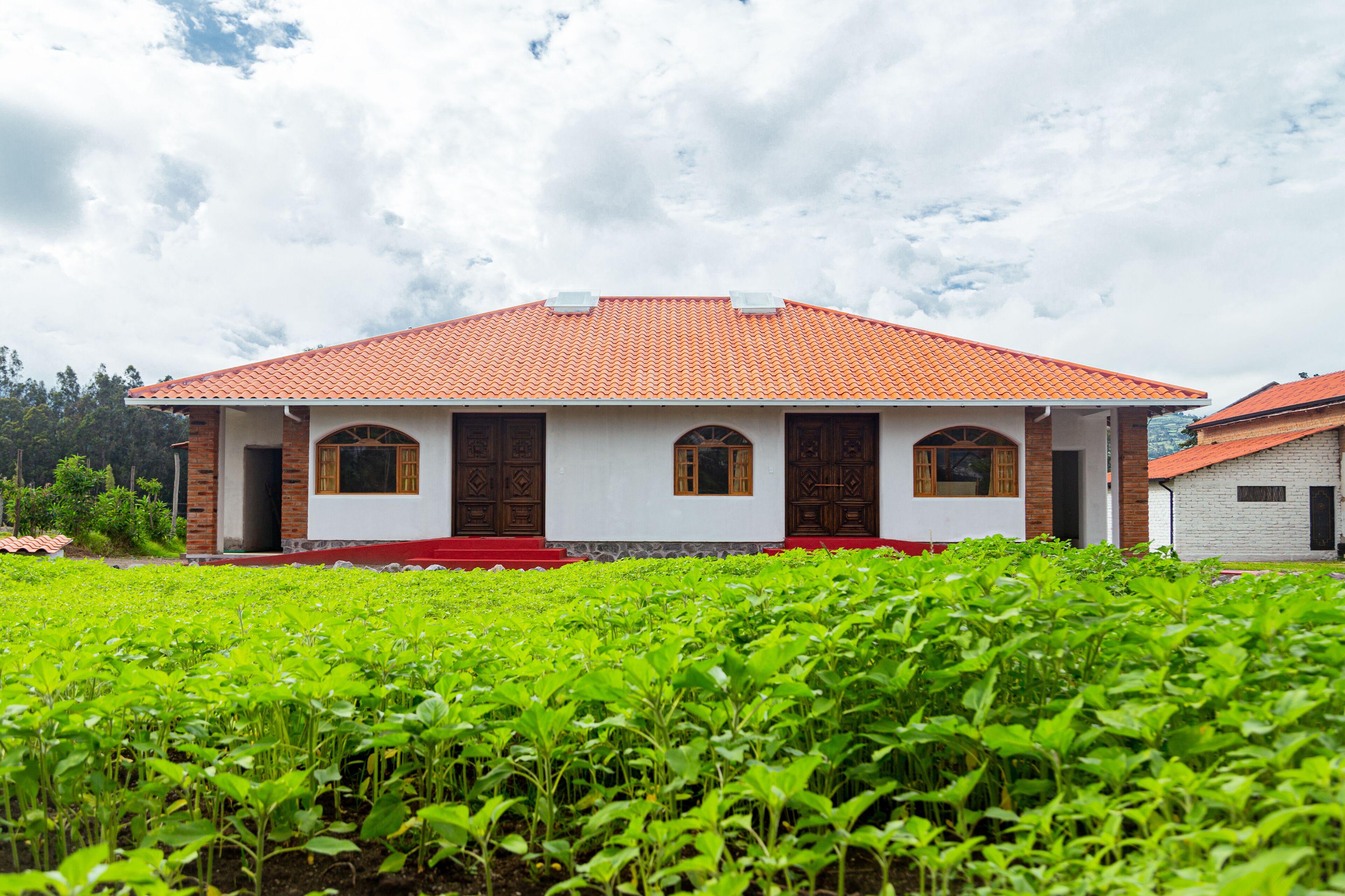 A two-story building with a red-tiled roof and a white facade.