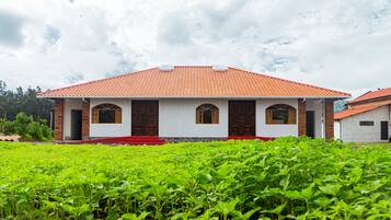 A two-story building with a red-tiled roof and a white facade.