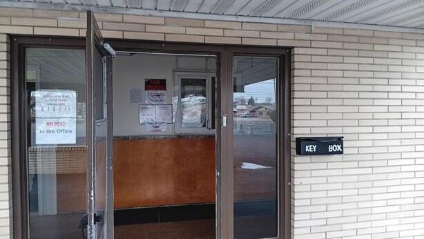 A building entrance with a glass door, a 'NO PETS' sign, a 'CHECK OUT TIME' sign, and a 'KEY BOX' sign. - DuBois Manor Motel  (DuBois)