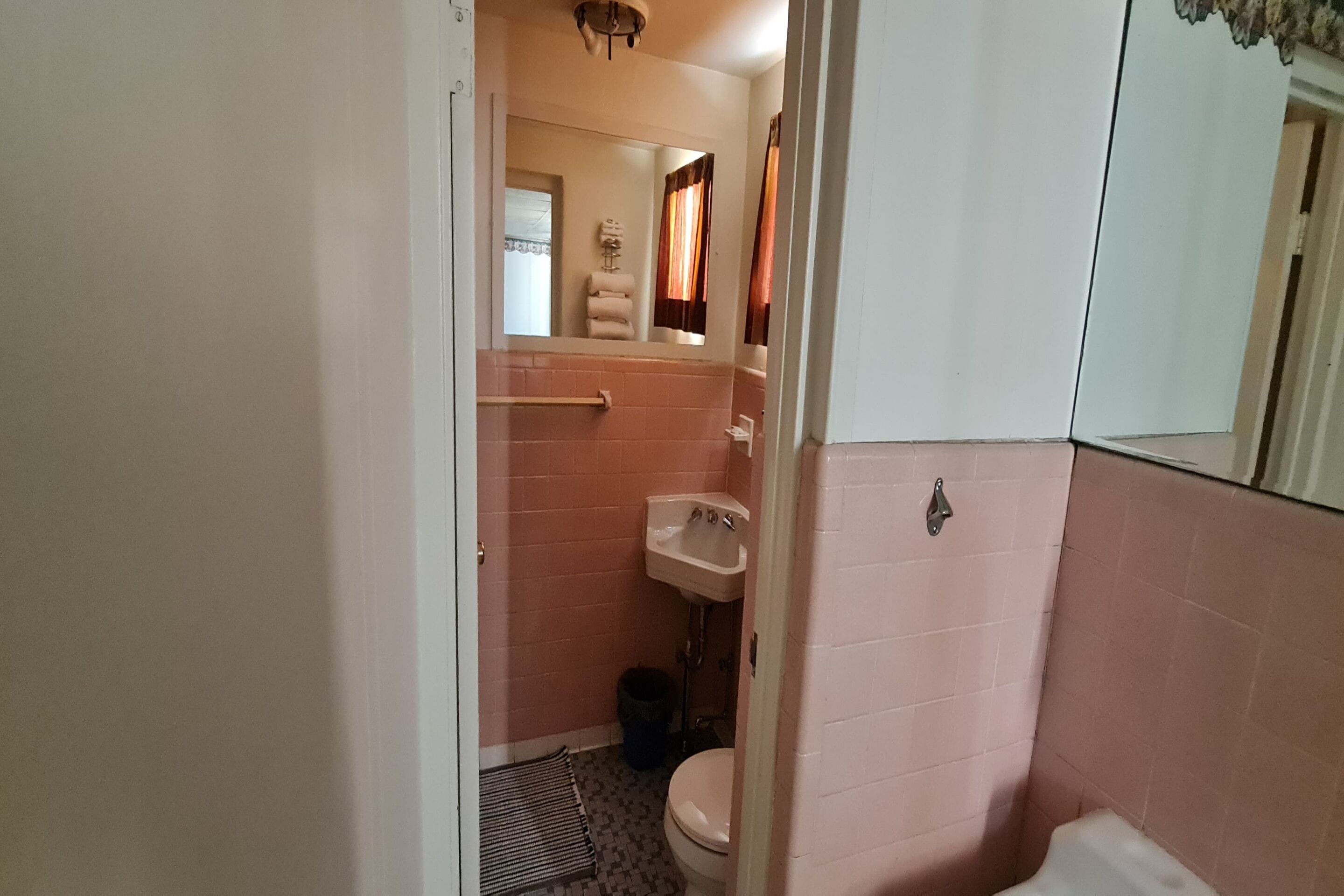 Une petite salle de bain avec des toilettes, un lavabo et un miroir.