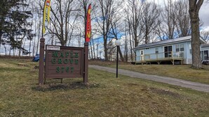 A wooden sign with 'Maple Grove 3767' and 'Seasonal Rentals' information.