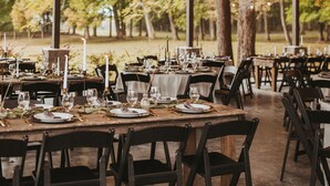 An outdoor dining area with tables set for a meal, surrounded by trees and a covered roof structure. - Scenic, Full-Hookup Back-In Campsite Just Outside Nashville! (Mt. Juliet)