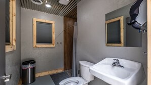 A compact bathroom with a toilet, sink, and shower. - Scenic, Full-Hookup Back-In Campsite Just Outside Nashville! (Mt. Juliet)