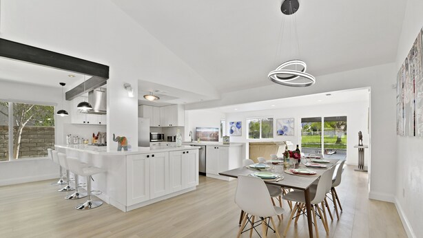 A modern kitchen with white cabinetry, a central island, and bar stools. - Luxury Villa: Pool, Spa, Golf Views  Sleeps 12 (Indio)