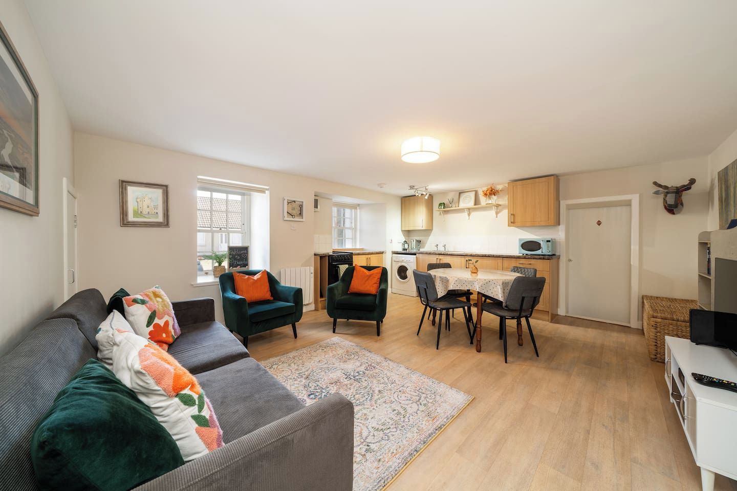 A modern apartment with a living room, dining area, and kitchen.