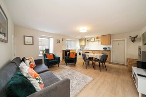 A modern apartment with a living room, dining area, and kitchen. - Unique Castle Stay in Perth - Corporate & Couples (Perth)
