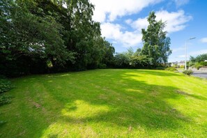 A well-maintained grassy area with trees and a street lamp. - Unique Castle Stay in Perth - Corporate & Couples (Perth)