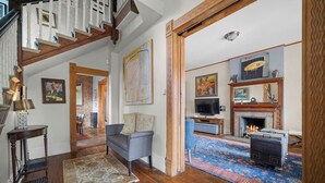 A spacious living room with a fireplace, a television, and a comfortable seating area. - Artsy Victorian I Near RINO I Downtown (Denver)
