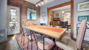 A dining area with a long wooden table, chairs, and a patterned rug. - Artsy Victorian I Near RINO I Downtown (Denver)