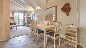 A dining area with a wooden table and chairs, a mirror, and a small wooden cabinet with bottles. - Fireplace I Pool I Biking I Skiing & Snowboarding (Silverthorne)