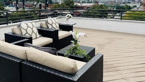A rooftop patio with outdoor furniture and a city skyline view. - Luxury Loft I Skyline Views in RiNO (Denver)