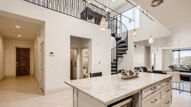 A spacious kitchen with a central island, a built-in oven, and a stainless steel staircase. - Luxury Loft I Skyline Views in RiNO (Denver)