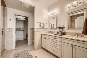 A bathroom with a double sink vanity, a large mirror, and a towel rack. - Luxury Loft I Skyline Views in RiNO (Denver)