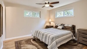 A bedroom with a bed, nightstands, a ceiling fan, and two windows. - Pet Friendly I 3bd I Red Rocks I Belmar I Denver (Lakewood)