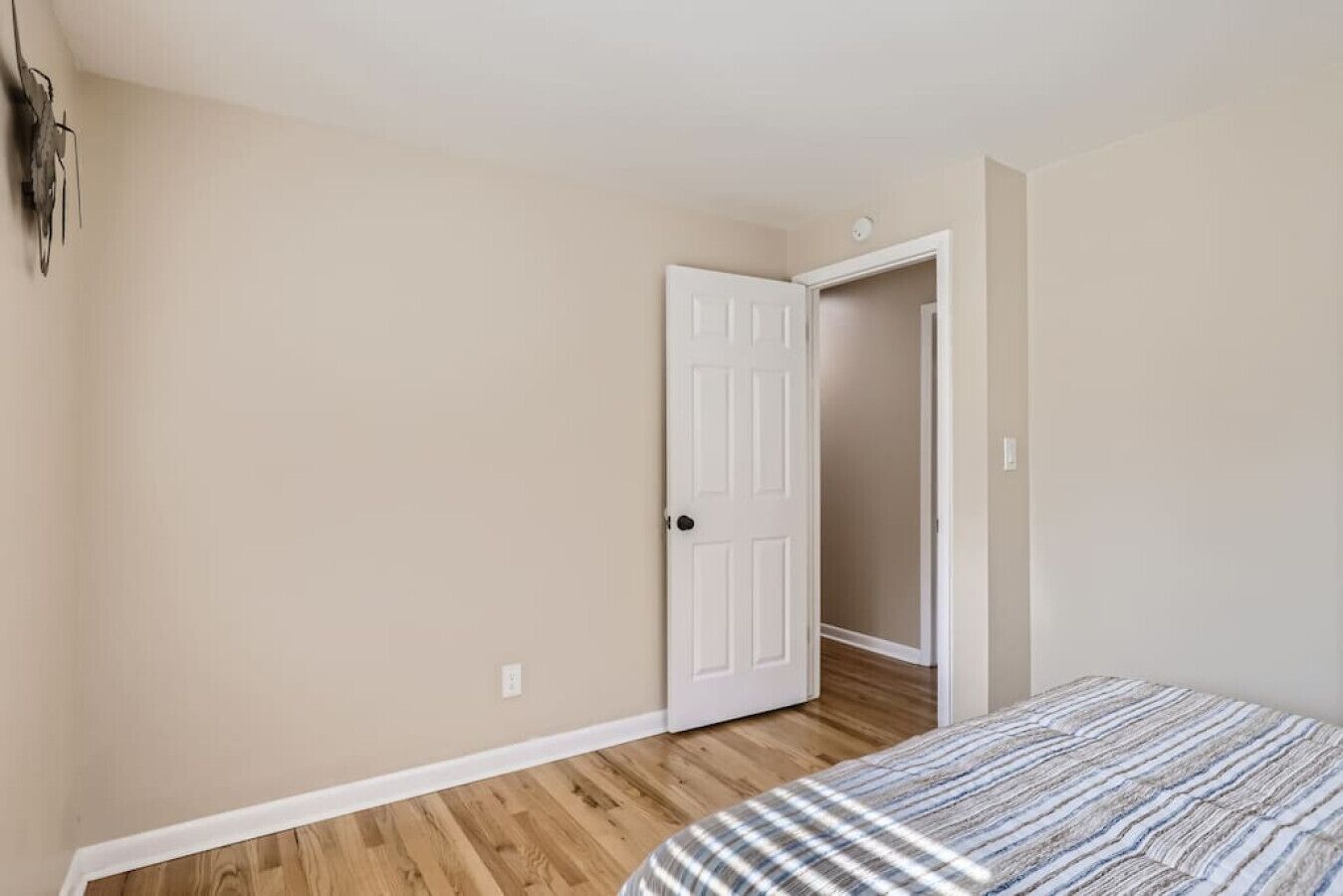 Ein Schlafzimmer mit Bett, Tür und Kleiderschrank.