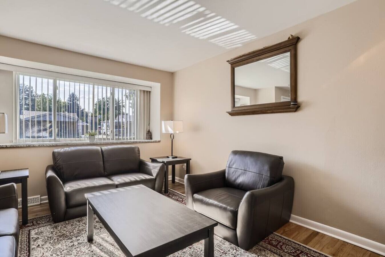 Un salon comprenant un canapé, un fauteuil, une table basse et une lampe.