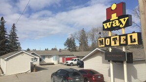 Ett motell med en stor skylt där det står ”Way Motel”, och ett antal parkerade bilar framför.