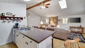 A modern kitchen with a granite countertop, white cabinetry, and a ceiling fan. - Family Friendly Cabin I Firepit+Hot Tub I Poconos (Pocono Pines)