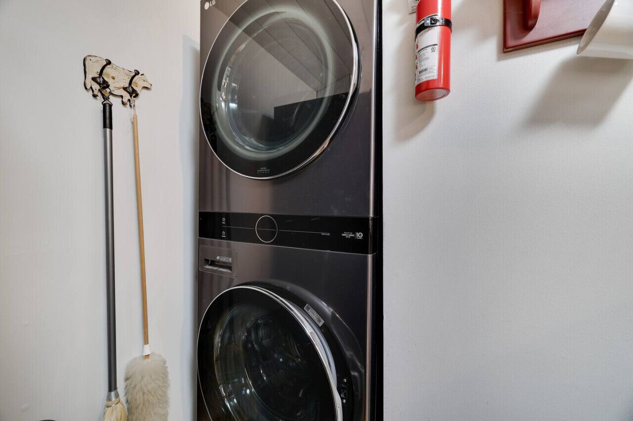 Een voorlader wasmachine en een dweil die tegen een muur leunt.