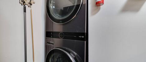 Een voorlader wasmachine en een dweil die tegen een muur leunt.