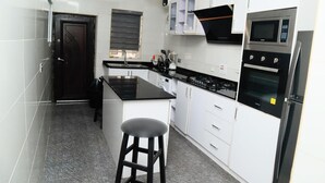 A modern kitchen with white cabinets, a black countertop, a built-in oven, and a gas stove. - 4 Bedroom Fully Detached Duplex in Lekki, Lagos (Lekki)