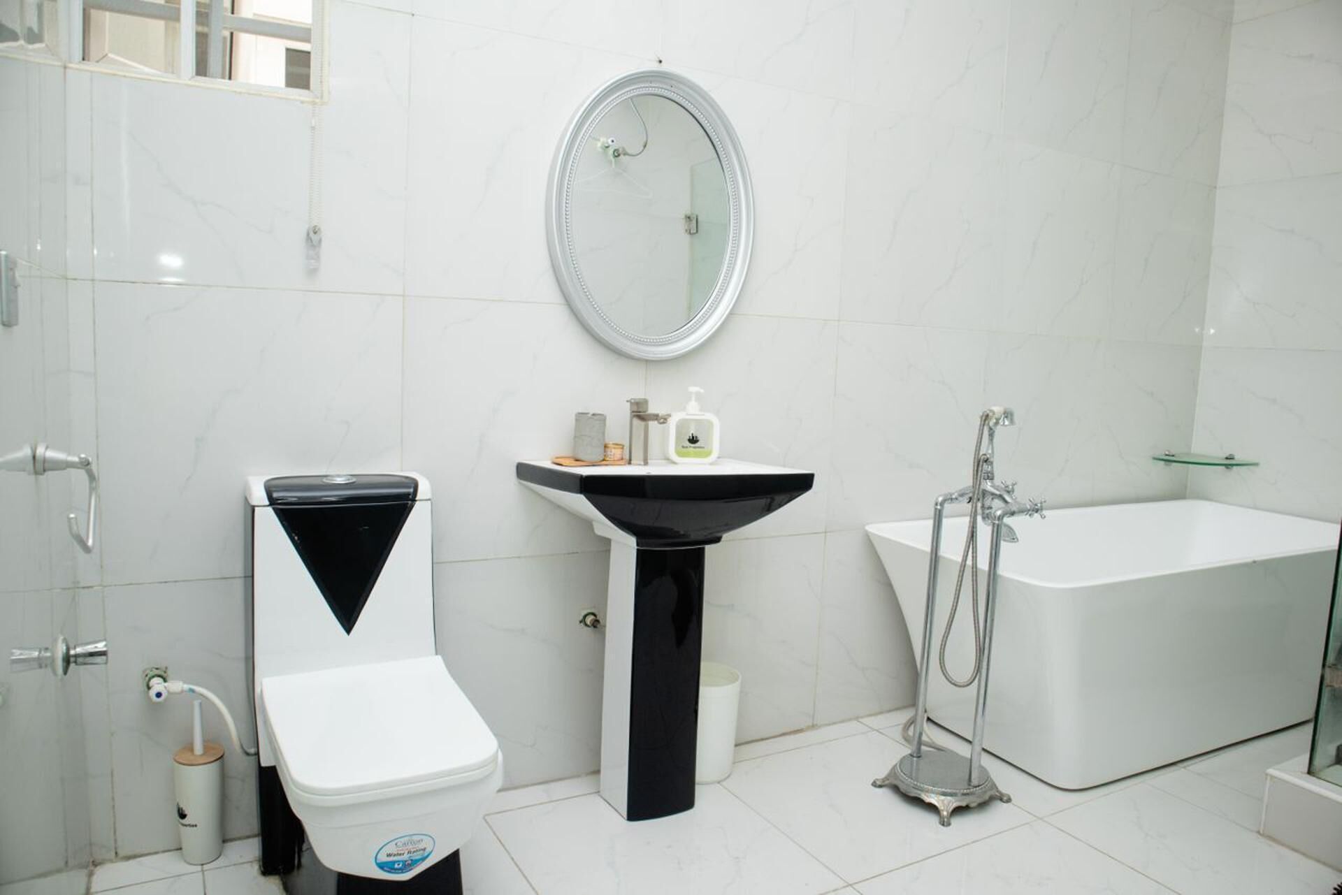 A modern bathroom with a toilet, sink, and bathtub.